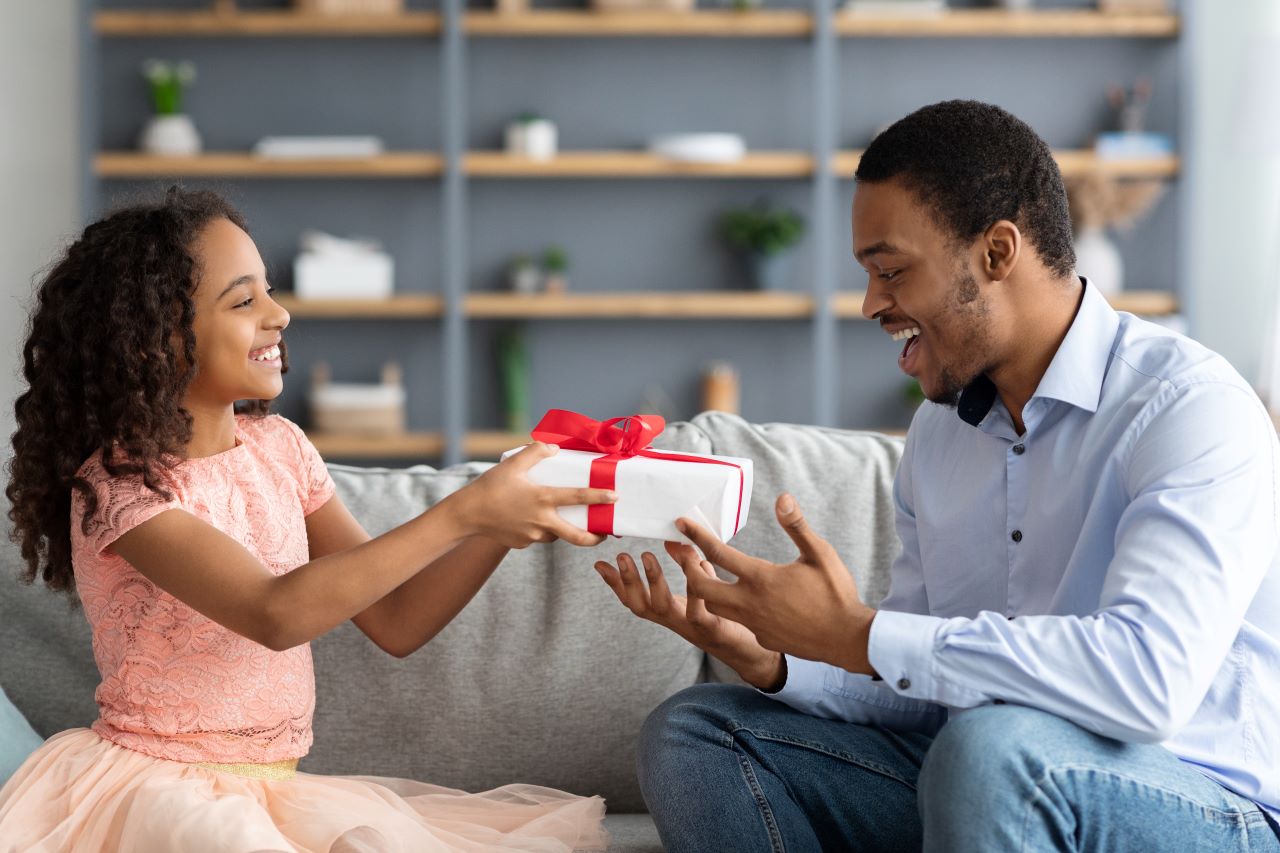 A little girl giving her dad a gift for Father's Day