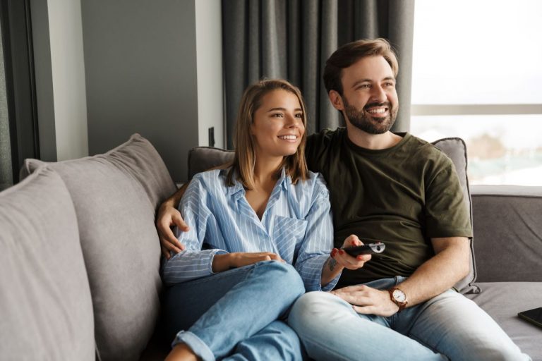 Couple watching tv on the couch.